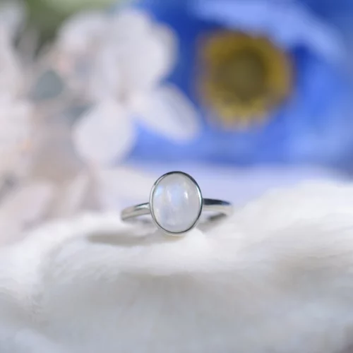 Introducing the Celestial Glow Moonstone Ring, a beautiful piece of sterling silver jewelry featuring a mesmerizing iridescent moonstone.